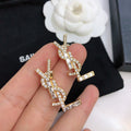 YSL 26S BAGUETTE CRYSTAL LOGO DROP EARRINGS IN GOLD TONE METAL 629136