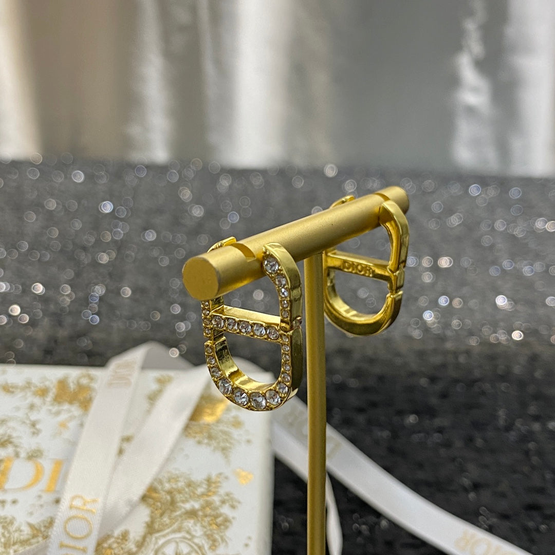 CD 26S CRYSTAL LOGO STUD EARRINGS IN GOLD TONE METAL 646502