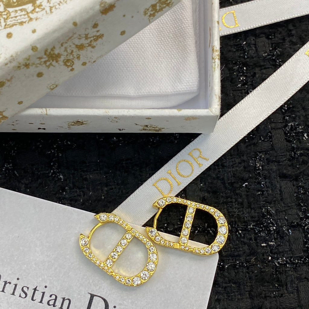 CD 26S CRYSTAL LOGO STUD EARRINGS IN GOLD TONE METAL 646502