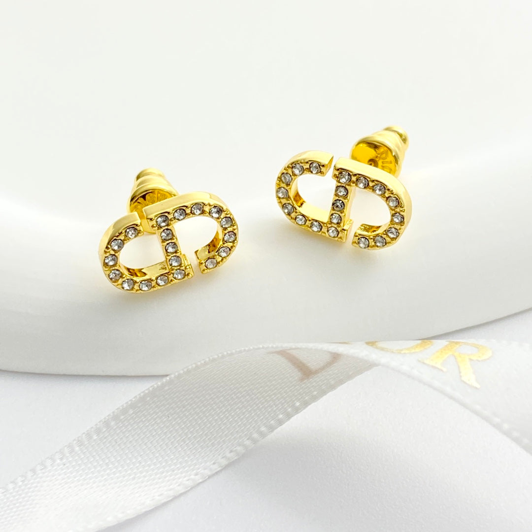 CD 26S CRYSTAL LOGO STUD EARRINGS IN GOLD METAL 633106