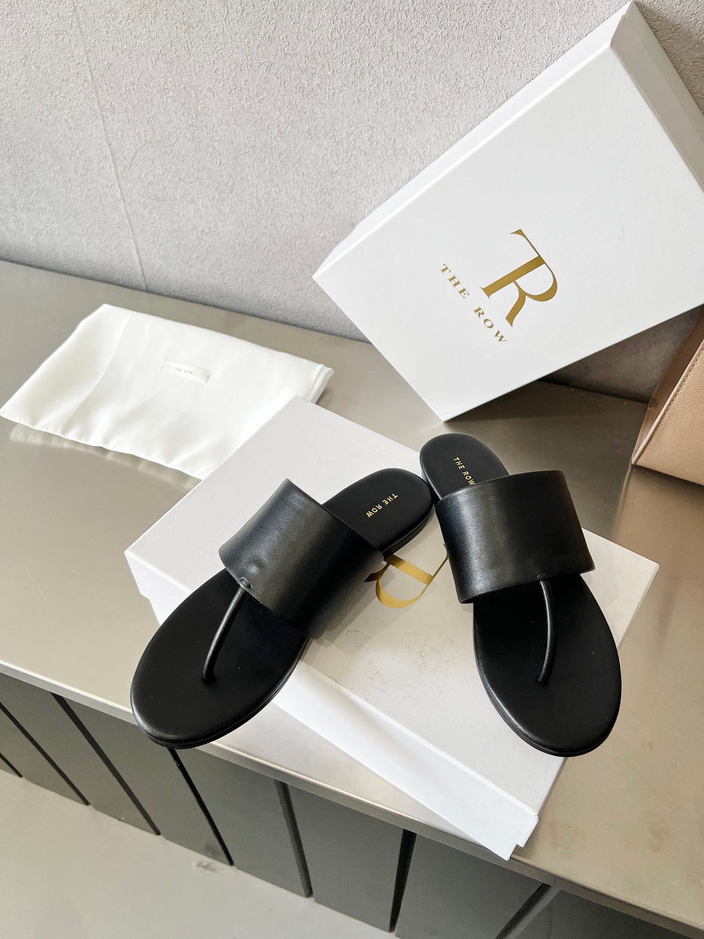 THE ROW 26S FLAT THONG SANDALS IN BLACK CALFSKIN