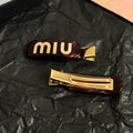 MIUMIU 26S LOGO HAIR CLIP IN BURGUNDY RESIN AND GOLD TONE METAL 625640