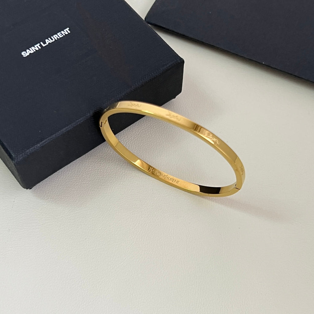 YSL 26S ENGRAVED LOGO BANGLE BRACELET IN GOLD TONE METAL 633272