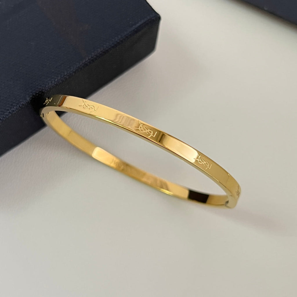 YSL 26S ENGRAVED LOGO BANGLE BRACELET IN GOLD TONE METAL 633272