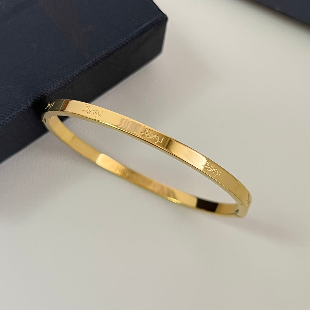 YSL 26S ENGRAVED LOGO BANGLE BRACELET IN GOLD TONE METAL 633272