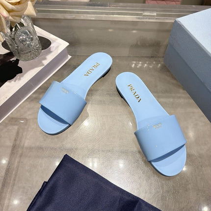 PRADA 26S LOGO EMBOSSED SLIDE SANDALS IN SKY BLUE PATENT CALFSKIN