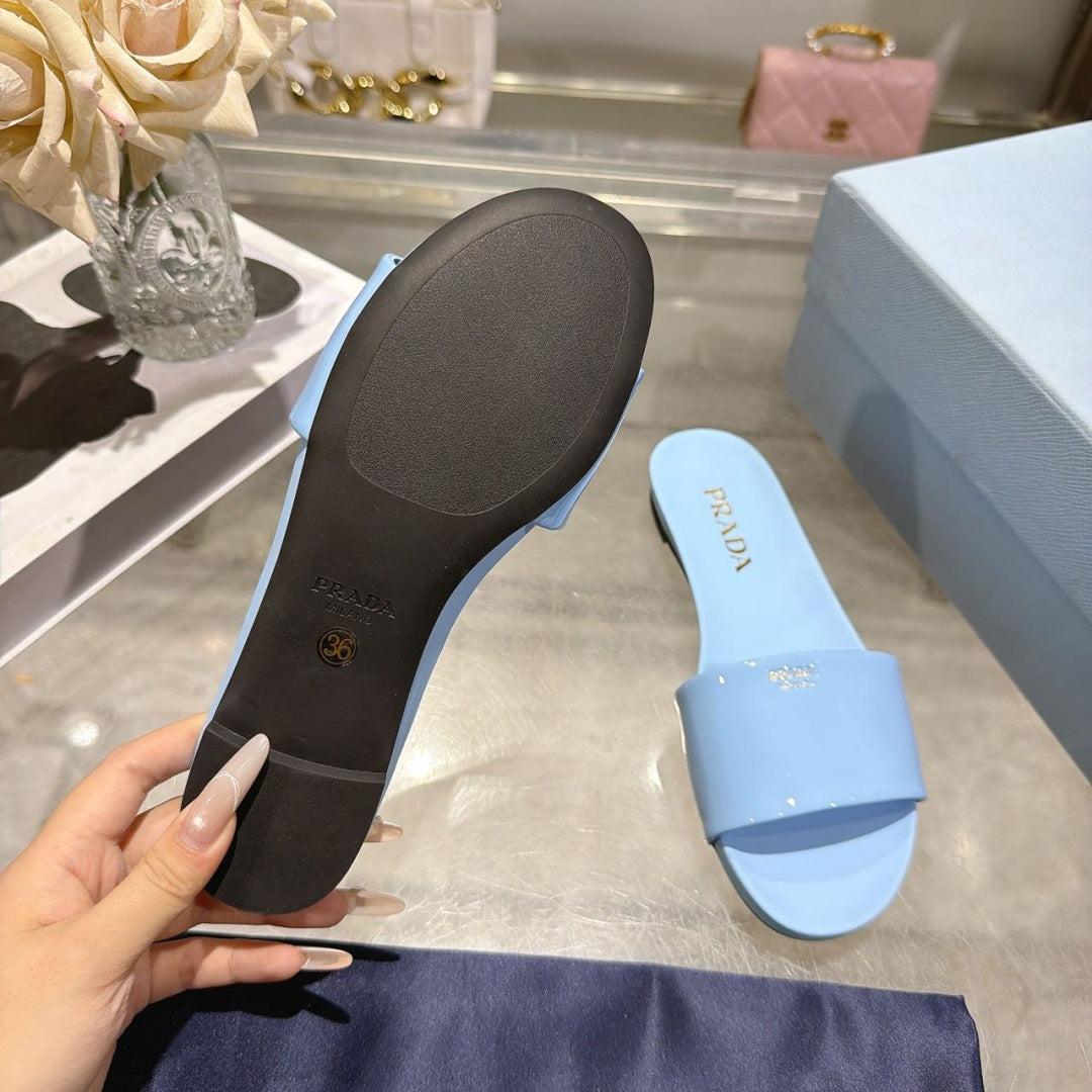 PRADA 26S LOGO EMBOSSED SLIDE SANDALS IN SKY BLUE PATENT CALFSKIN