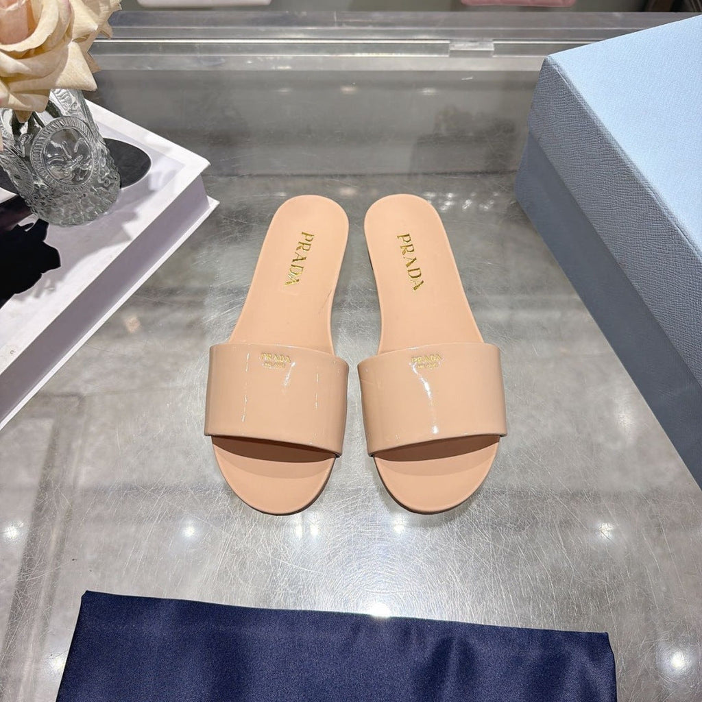PRADA 26S LOGO EMBOSSED SLIDE SANDALS IN NUDE BEIGE PATENT CALFSKIN