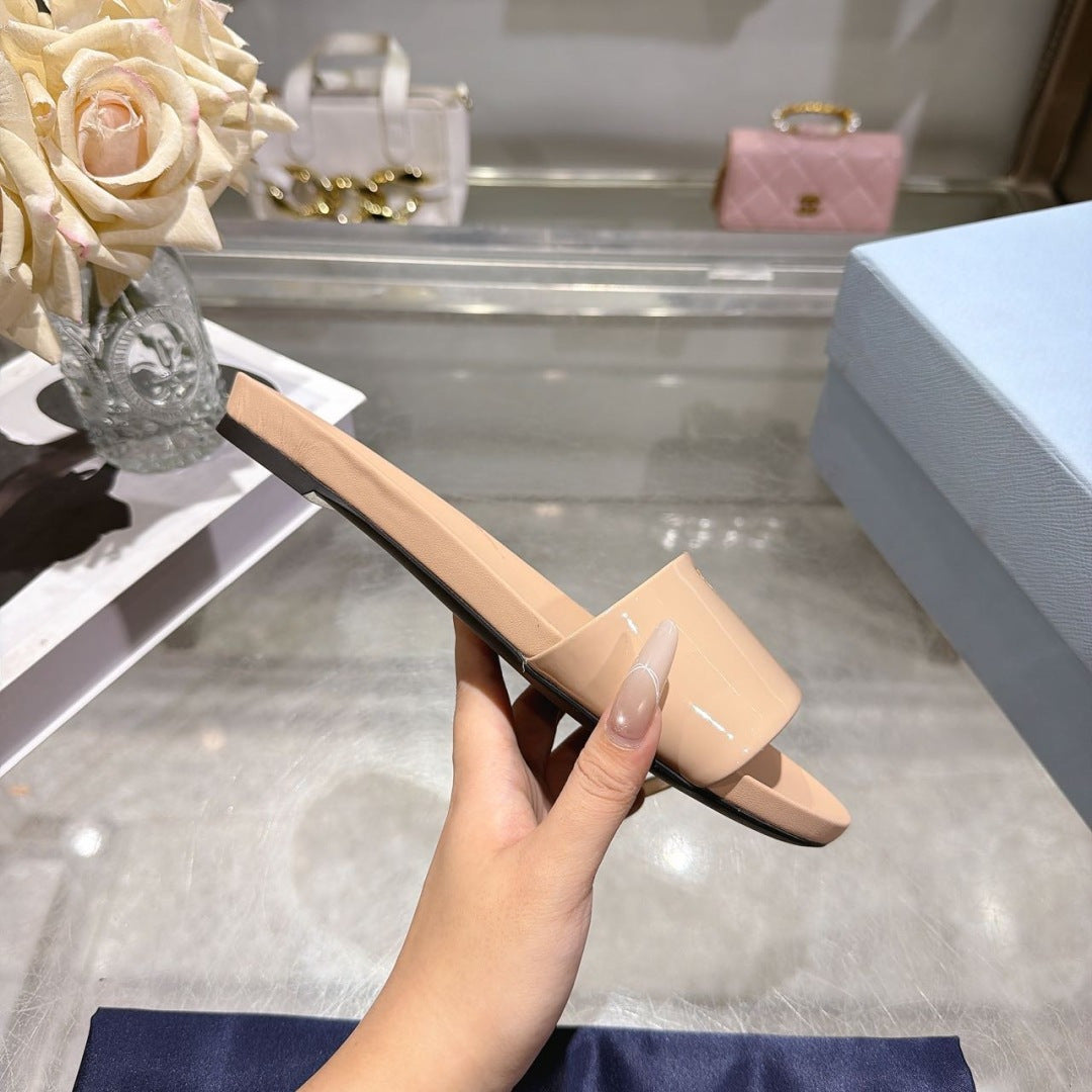 PRADA 26S LOGO EMBOSSED SLIDE SANDALS IN NUDE BEIGE PATENT CALFSKIN