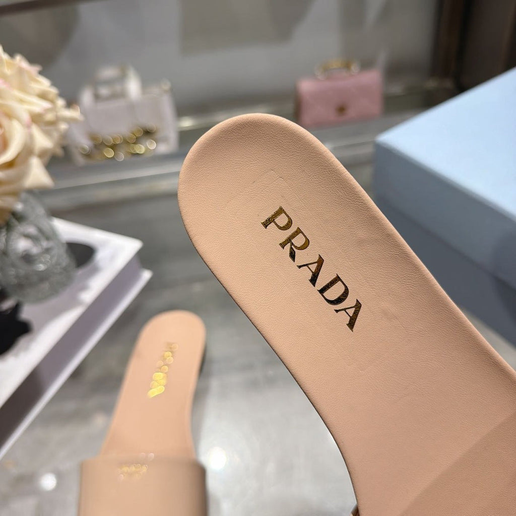 PRADA 26S LOGO EMBOSSED SLIDE SANDALS IN NUDE BEIGE PATENT CALFSKIN