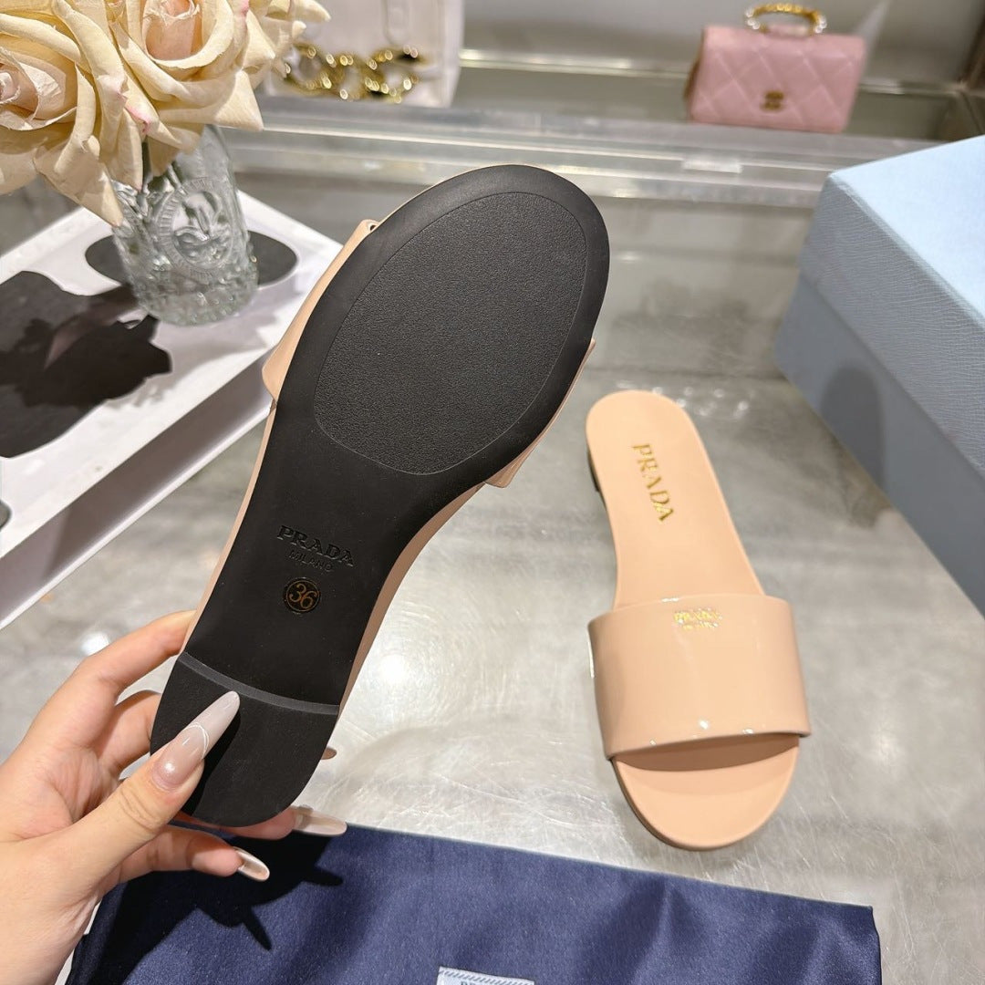 PRADA 26S LOGO EMBOSSED SLIDE SANDALS IN NUDE BEIGE PATENT CALFSKIN