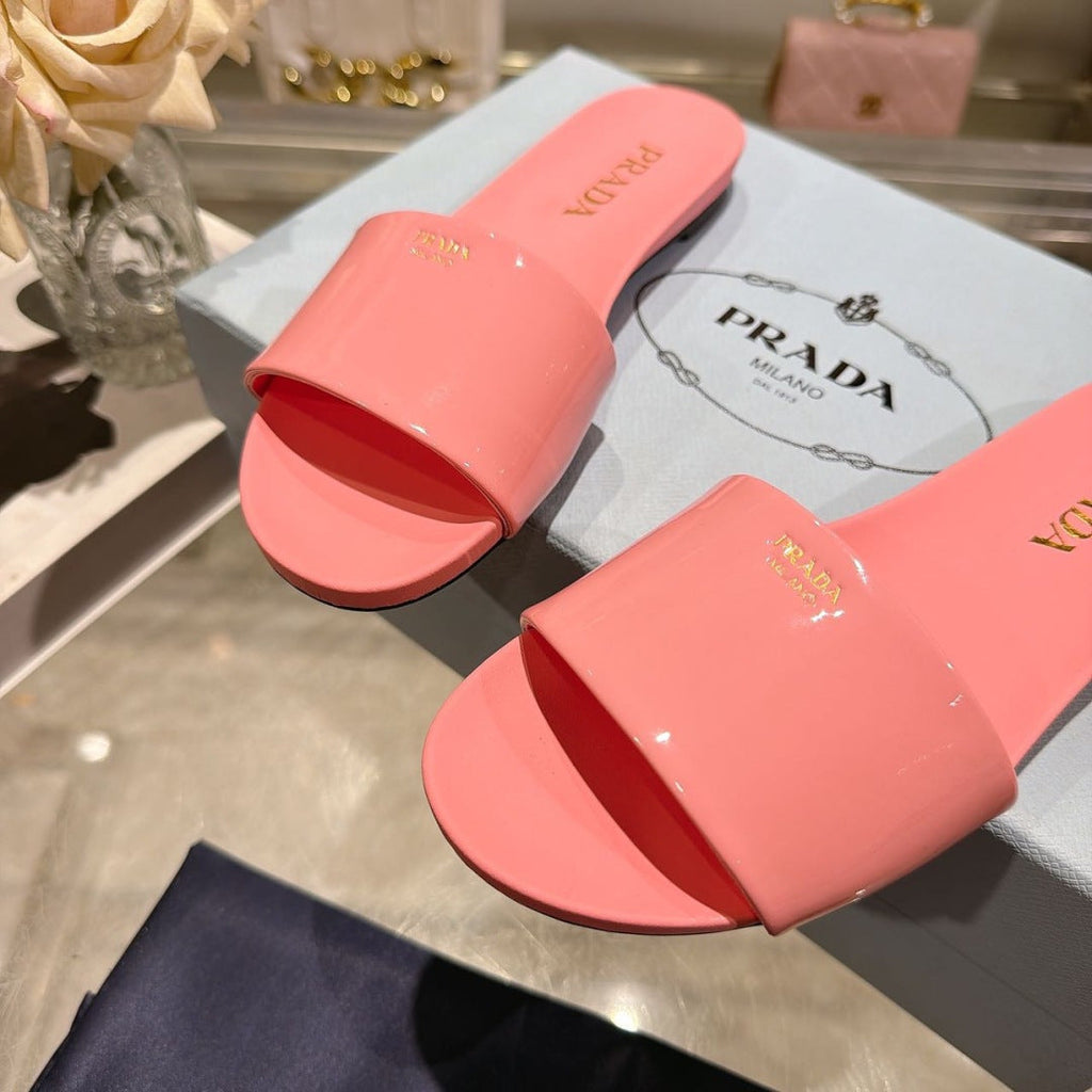 PRADA 26S LOGO EMBOSSED SLIDE SANDALS IN PINK PATENT CALFSKIN