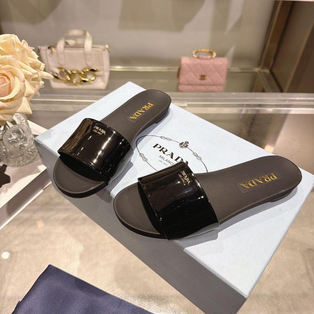 PRADA 26S LOGO EMBOSSED SLIDE SANDALS IN BLACK PATENT CALFSKIN