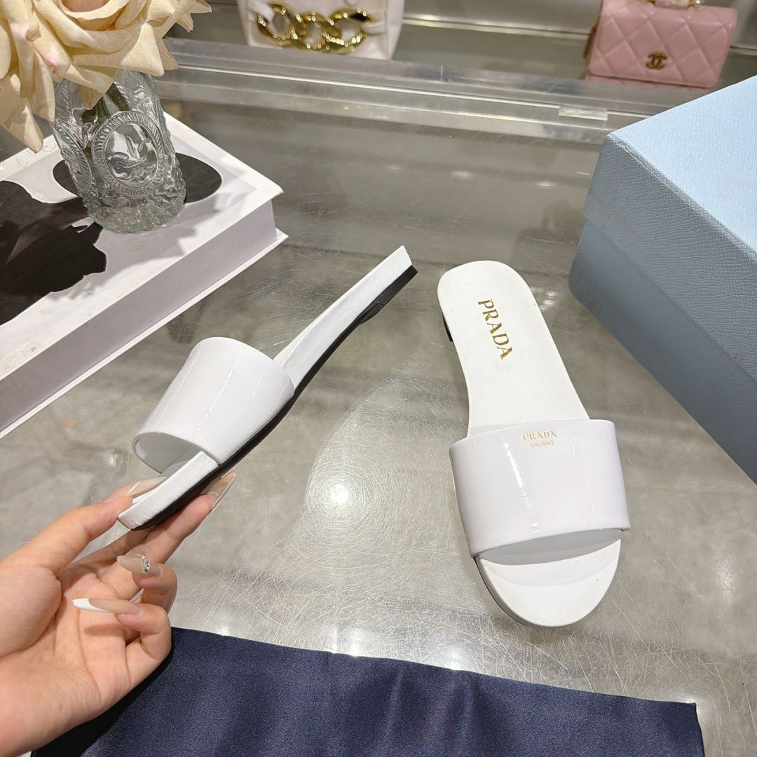PRADA 26S LOGO EMBOSSED SLIDE SANDALS IN WHITE PATENT CALFSKIN