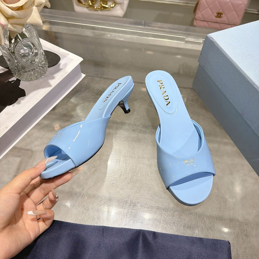 PRADA 26S LOGO EMBOSSED KITTEN HEEL MULES IN SKY BLUE PATENT CALFSKIN