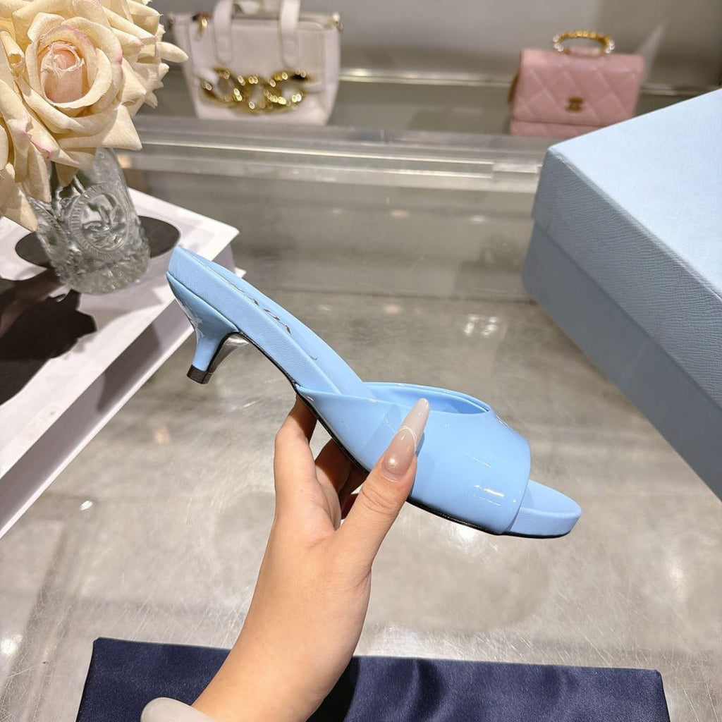 PRADA 26S LOGO EMBOSSED KITTEN HEEL MULES IN SKY BLUE PATENT CALFSKIN