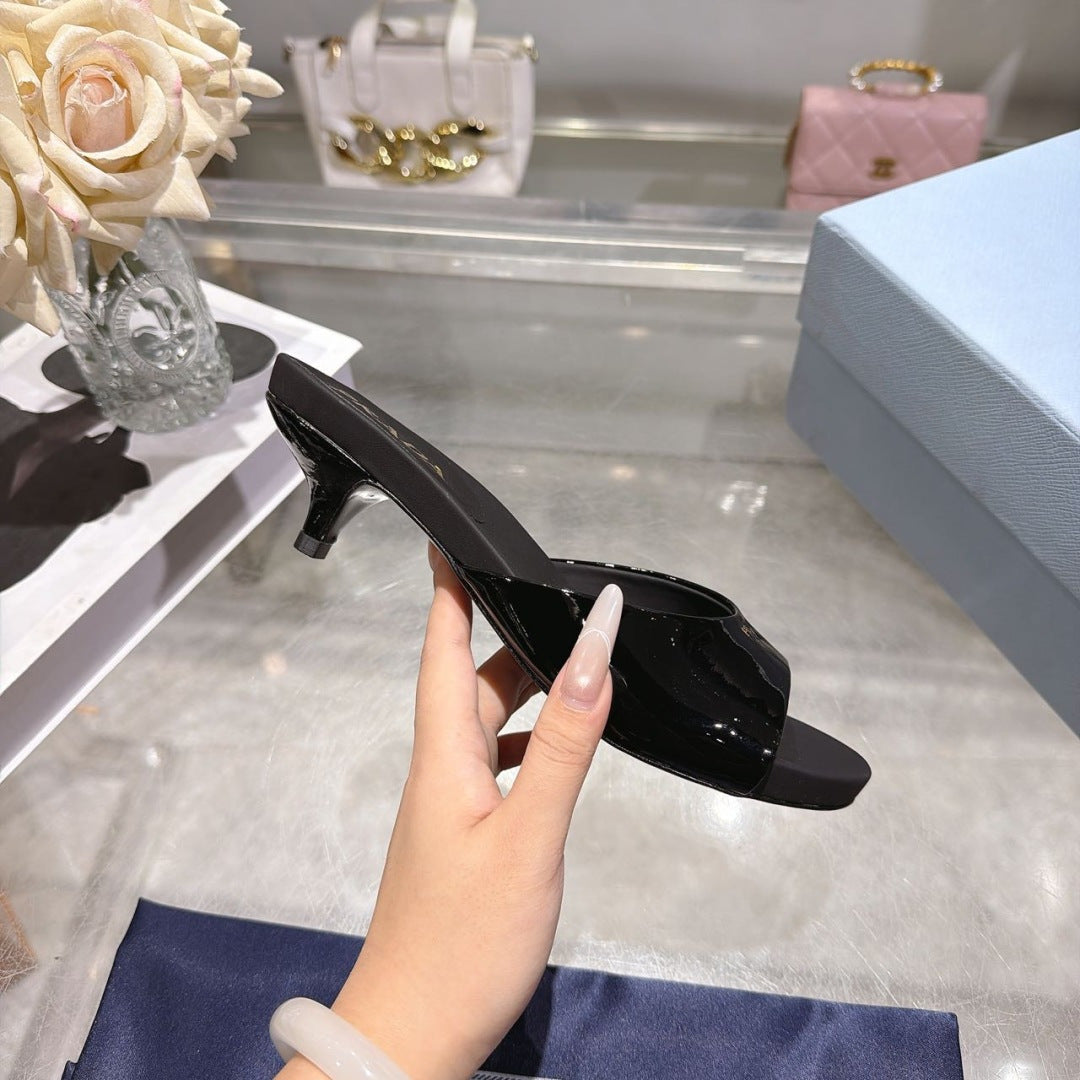 PRADA 26S LOGO EMBOSSED KITTEN HEEL MULES IN BLACK PATENT CALFSKIN