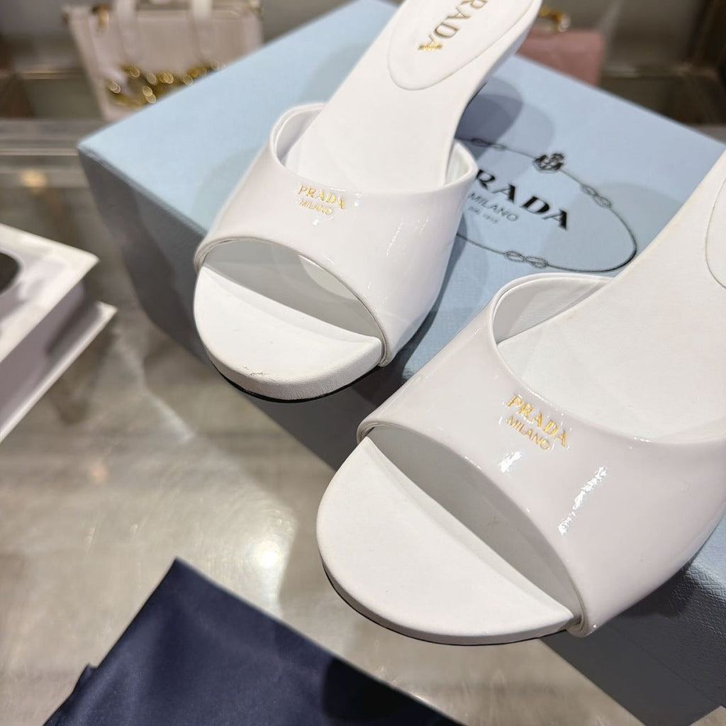 PRADA 26S LOGO EMBOSSED KITTEN HEEL MULES IN WHITE PATENT CALFSKIN