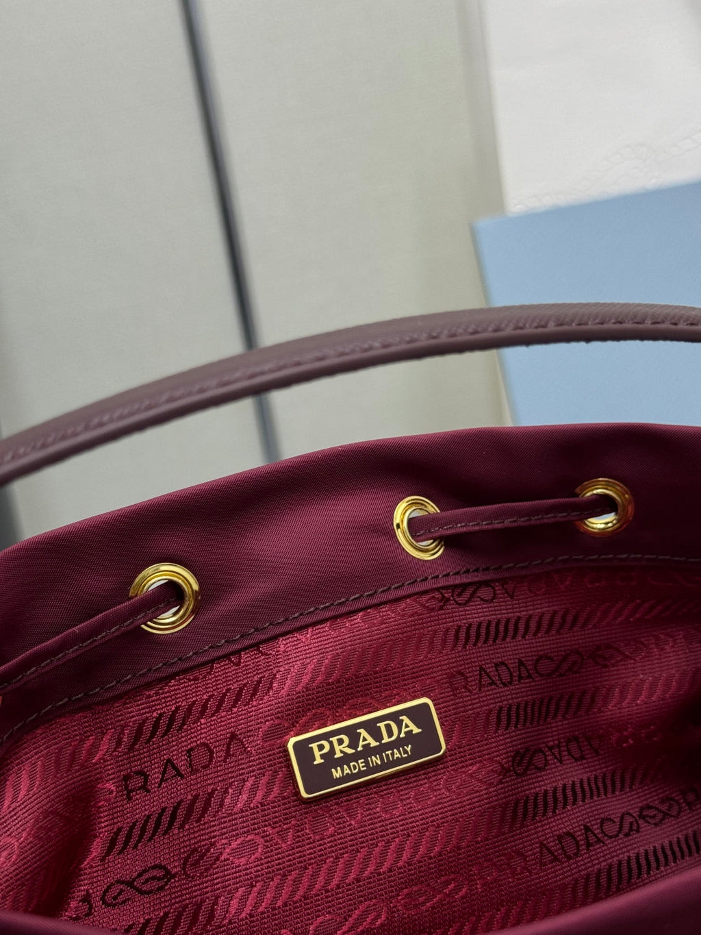 PRADA 25S DUET BUCKET BAG 23 IN BURGUNDY RE-NYLON GOLD HARDWARE