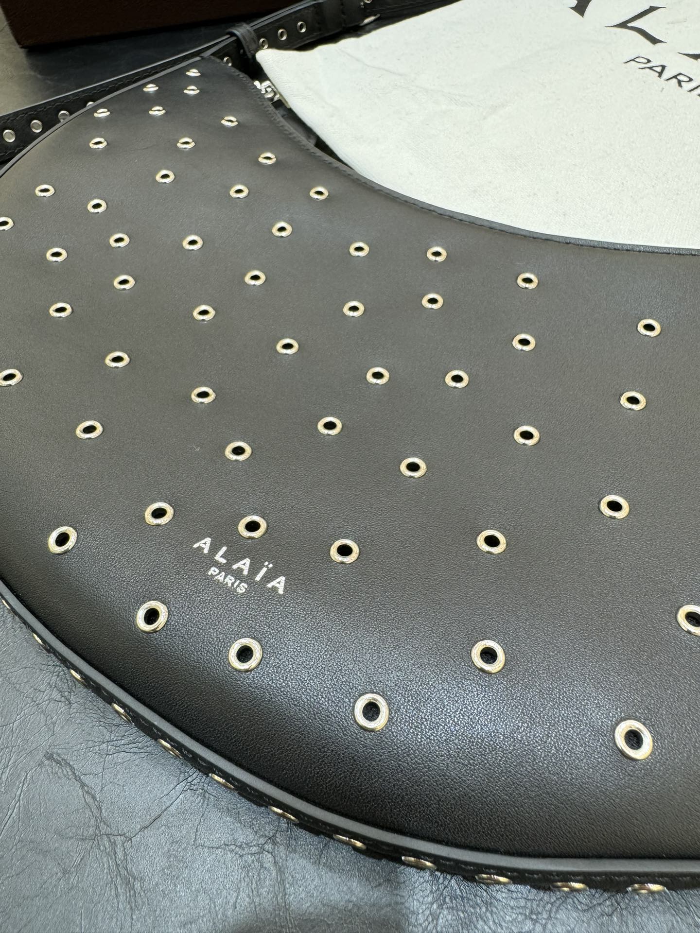 ONE PIECE DEMI LUNE BAG 31 IN BLACK SHEEPSKIN EYELET DETAILING