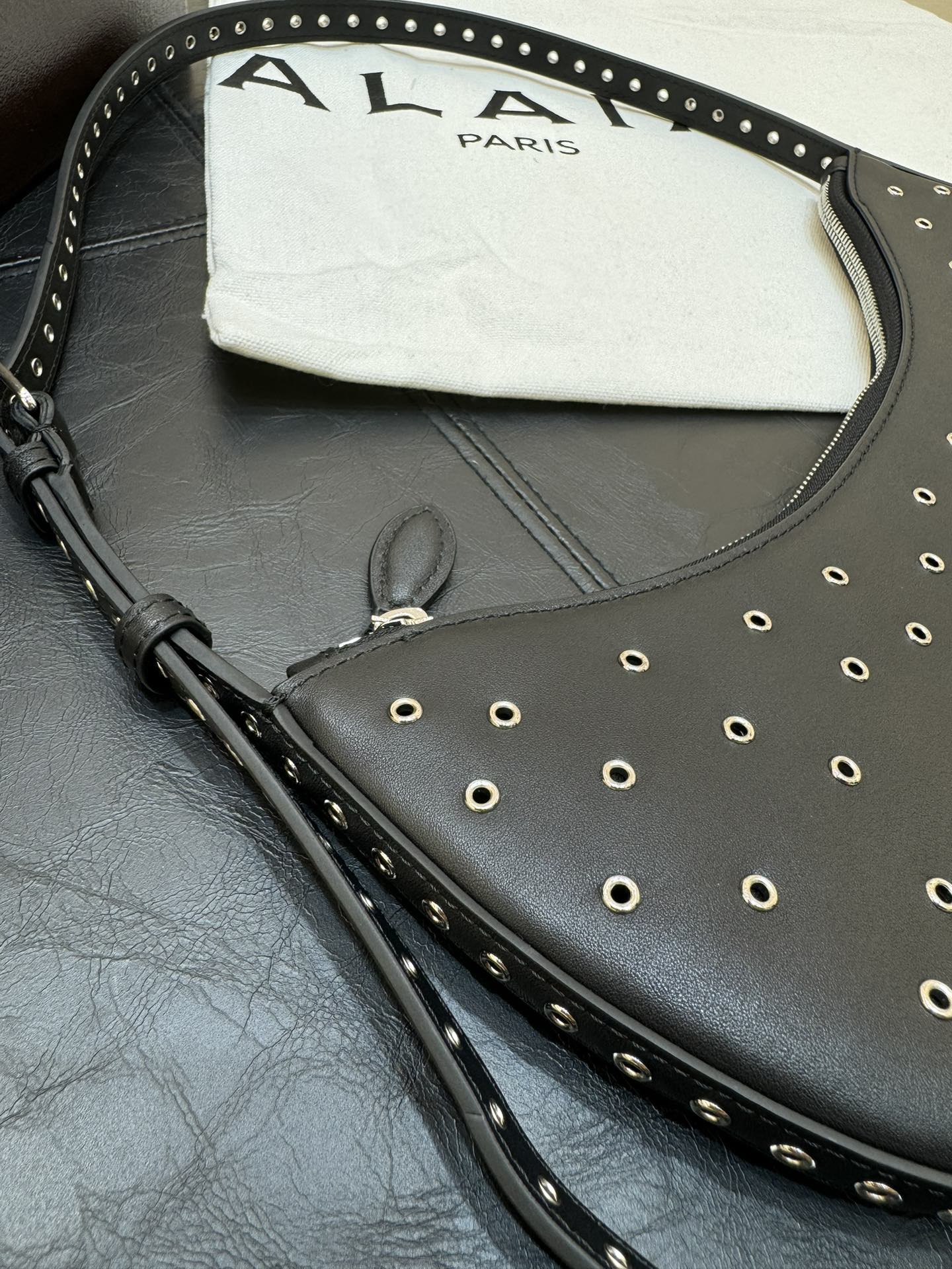ONE PIECE DEMI LUNE BAG 31 IN BLACK SHEEPSKIN EYELET DETAILING