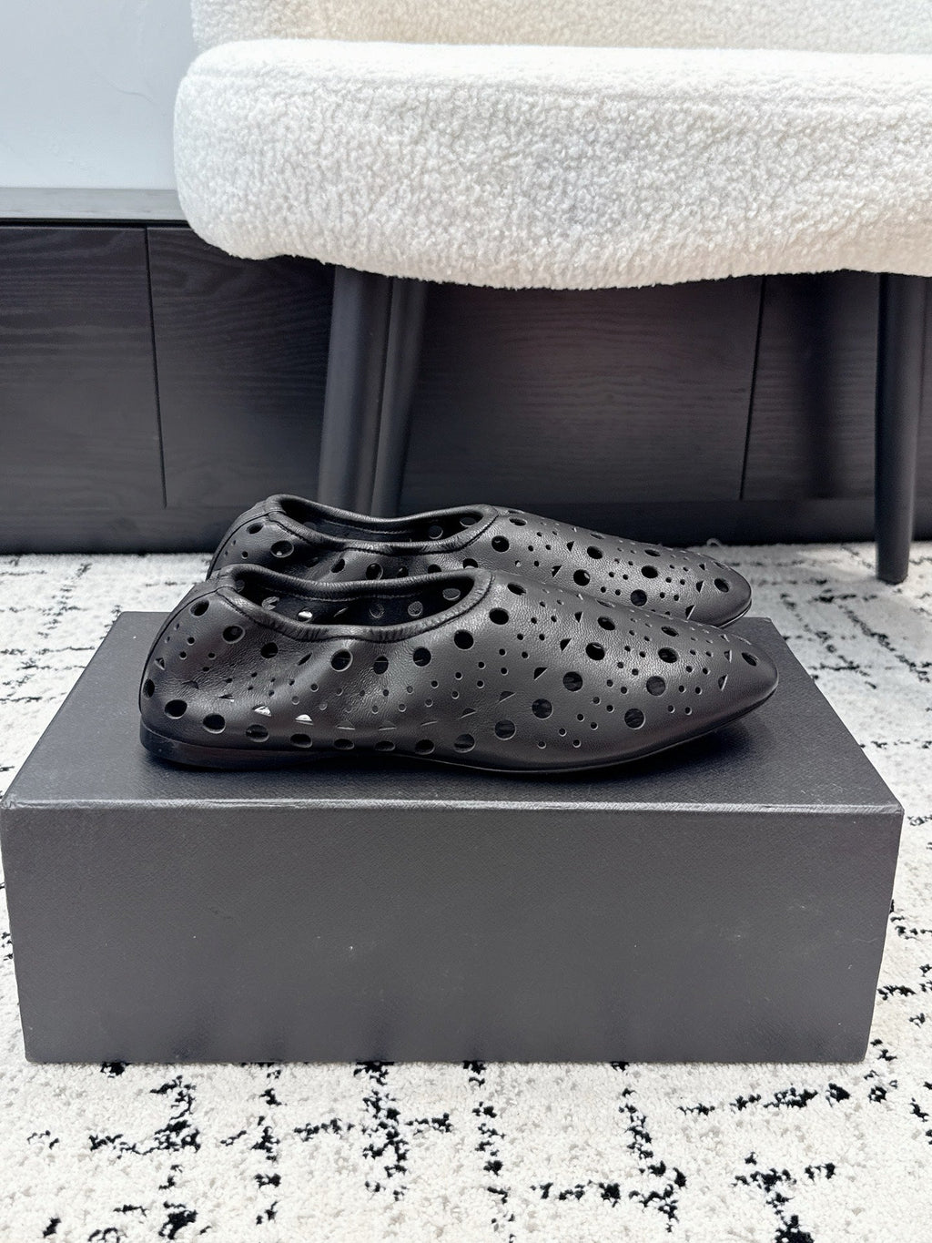 ALAIA 26S FLAT SLIP-ONS IN BLACK CALFSKIN WITH OPENWORK PATTERN