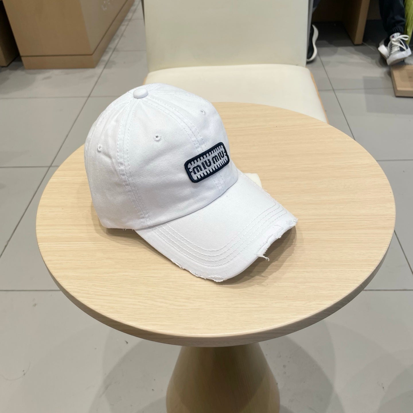 MIUMIU DISTRESSED FABRIC BASEBALL CAP IN WHITE WITH EMBROIDERED LOGO