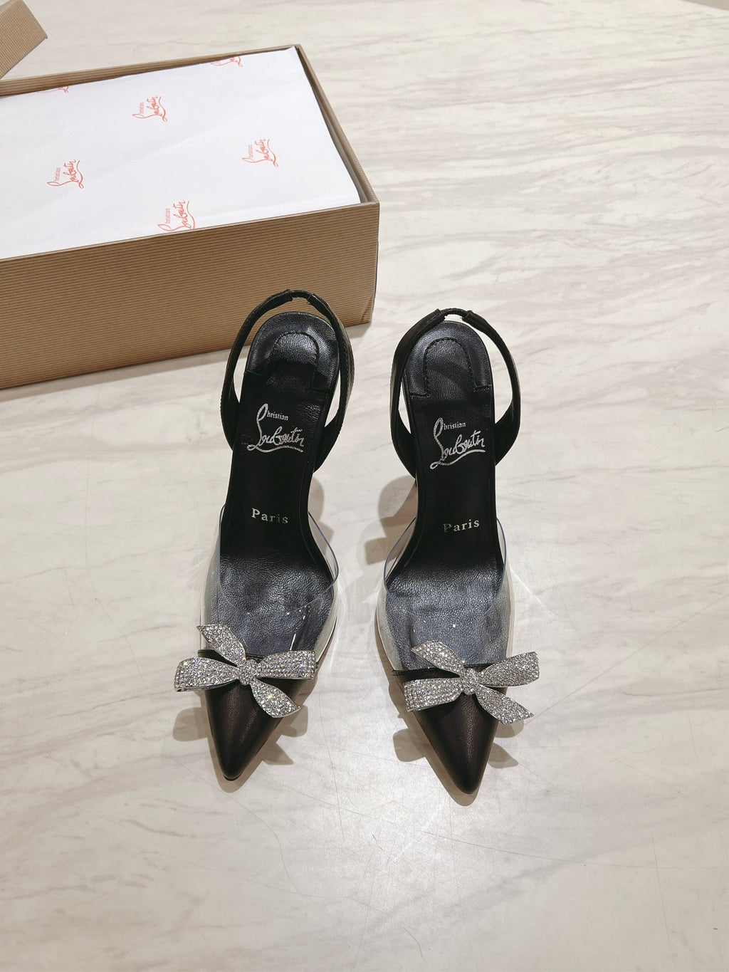 APOSTROPHA SLINGBACK PUMPS IN BLACK CALFSKIN AND CLEAR PVC JEWELED BOW
