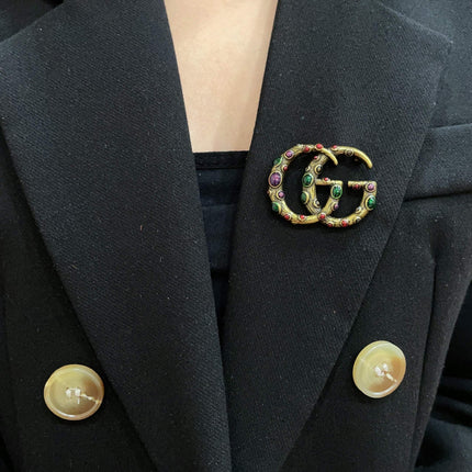 GUCCI 26S INTERLOCKING G MULTICOLOR GEM LOGO BROOCH IN ANTIQUE GOLD TONE METAL 625634