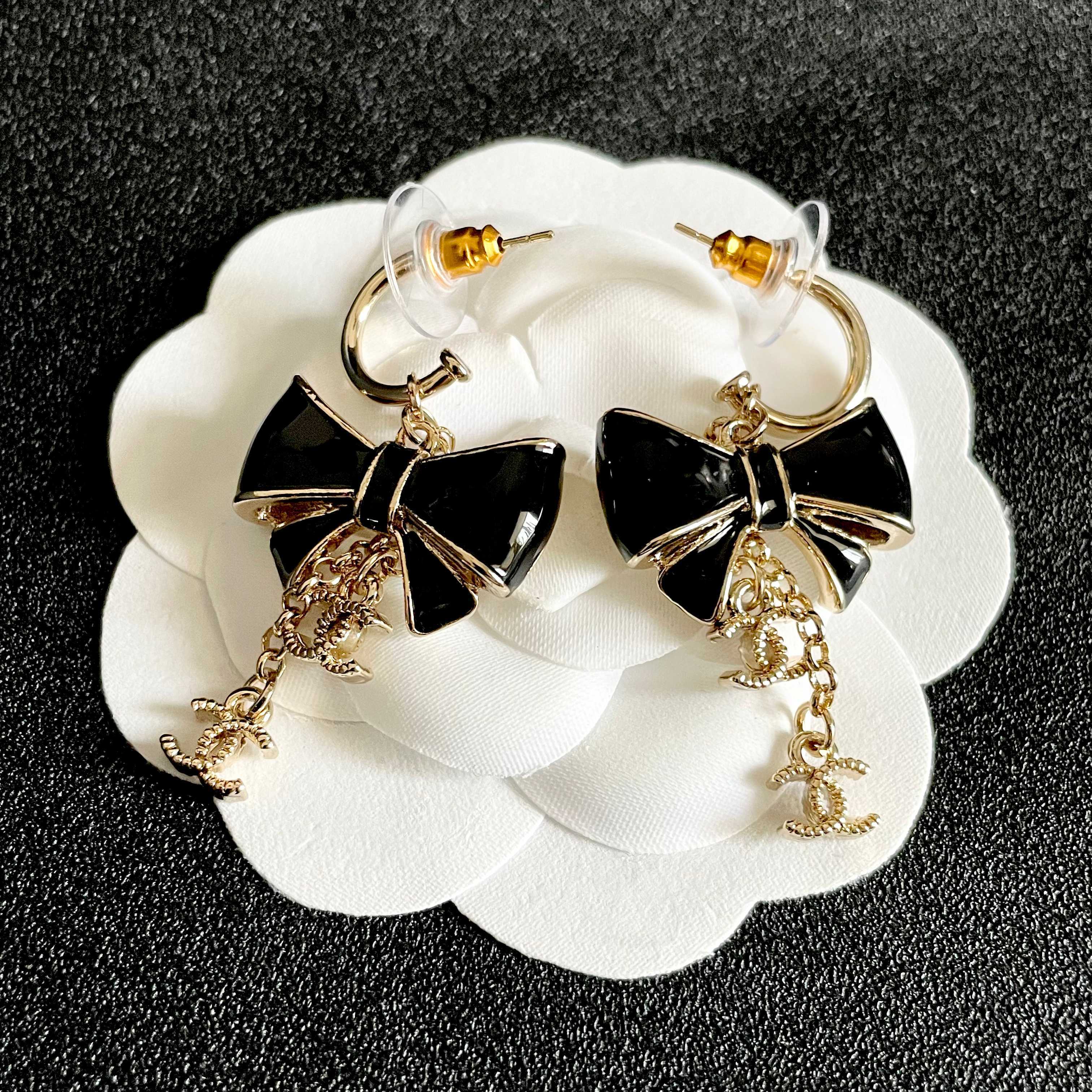 CHANEL 26S DOUBLE C LOGO BLACK ENAMEL BOW DANGLE EARRINGS WITH CHAIN CHARMS IN GOLD METAL 629178
