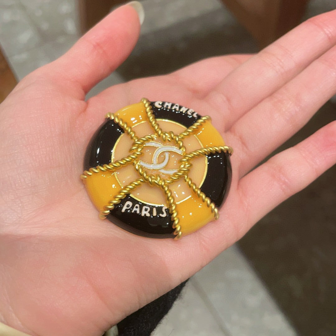 CHANEL 26S DOUBLE C LOGO PARIS ROUND ENAMEL BROOCH IN BLACK & AMBER WITH ROPE DETAIL GOLD METAL 629194
