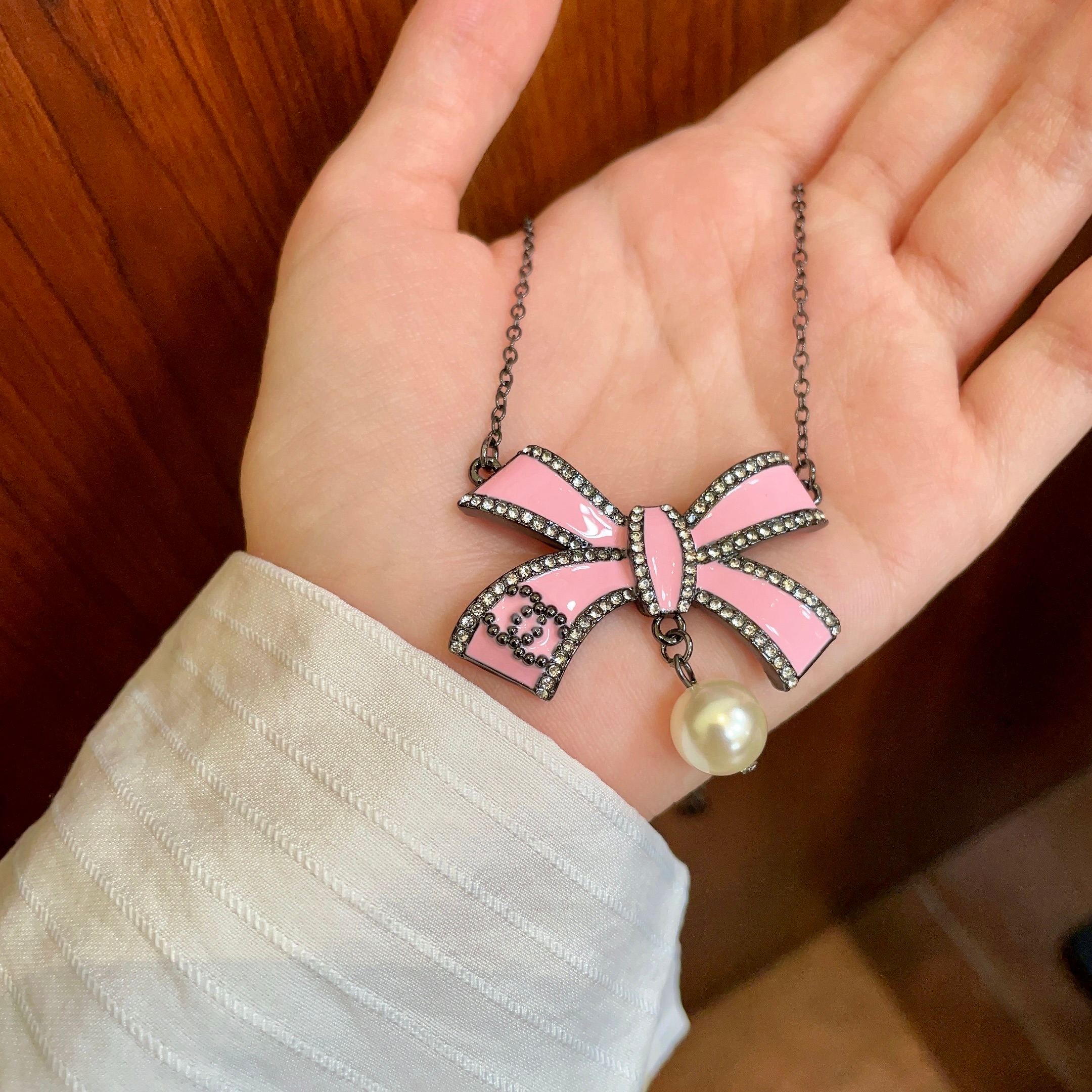 CHANEL 26S DOUBLE C LOGO PINK ENAMEL BOW & PEARL PENDANT NECKLACE IN BLACK METAL 629976