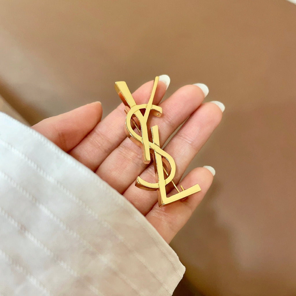 YSL 26S MONOGRAM BROOCH IN GOLD TONE METAL 630942