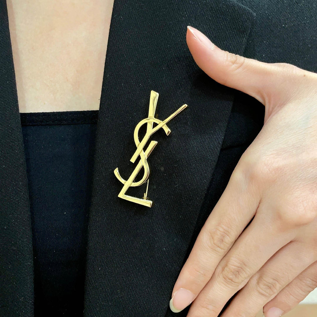 YSL 26S MONOGRAM BROOCH IN GOLD TONE METAL 630942