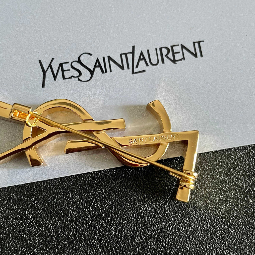YSL 26S MONOGRAM BROOCH IN GOLD TONE METAL 630942
