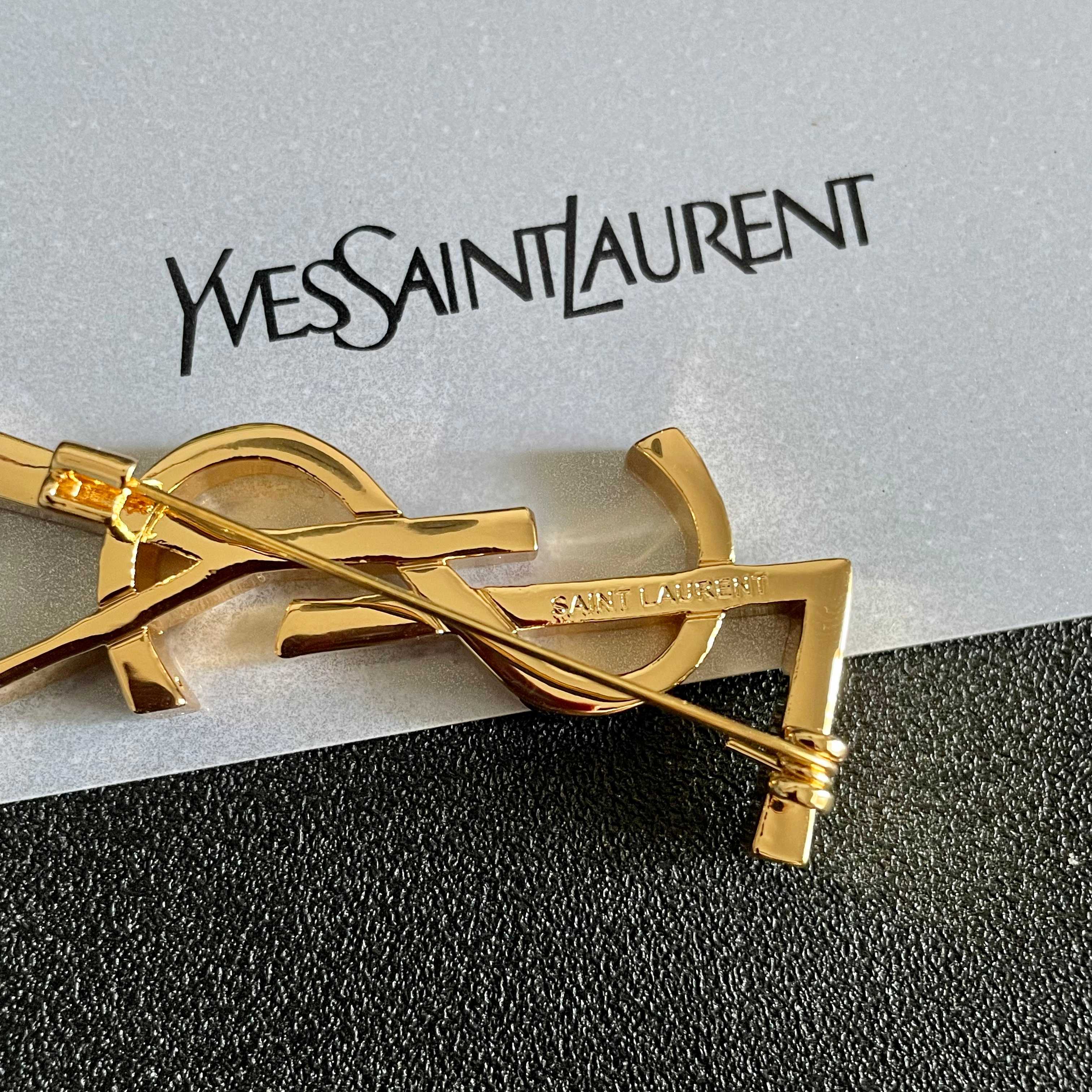 YSL 26S MONOGRAM BROOCH IN GOLD TONE METAL 630942