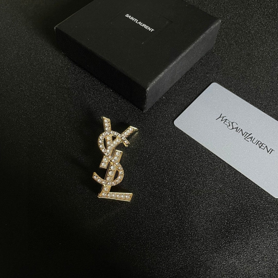 YSL 26S CRYSTAL MONOGRAM BROOCH IN GOLD TONE METAL 631043
