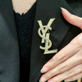 YSL 26S CRYSTAL MONOGRAM BROOCH IN GOLD TONE METAL 631043