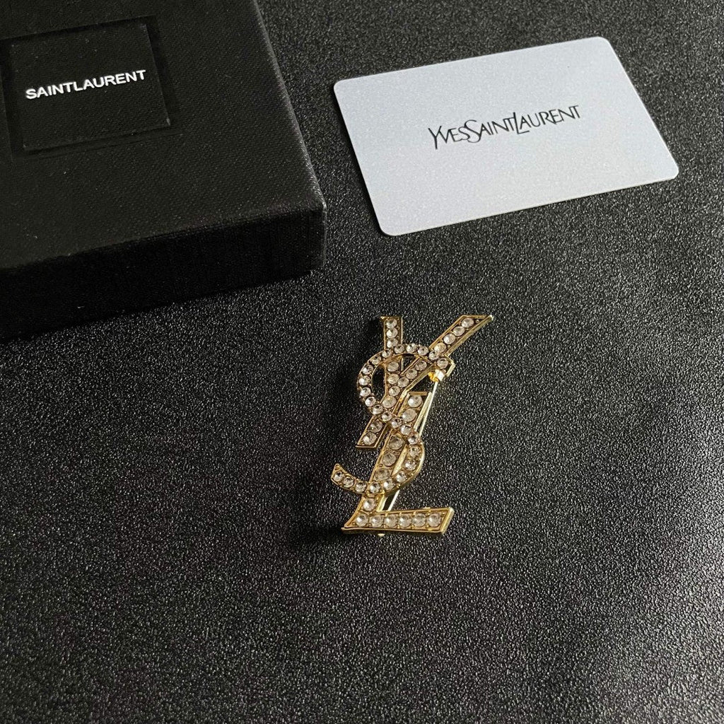 YSL 26S CRYSTAL MONOGRAM BROOCH IN GOLD TONE METAL 631043
