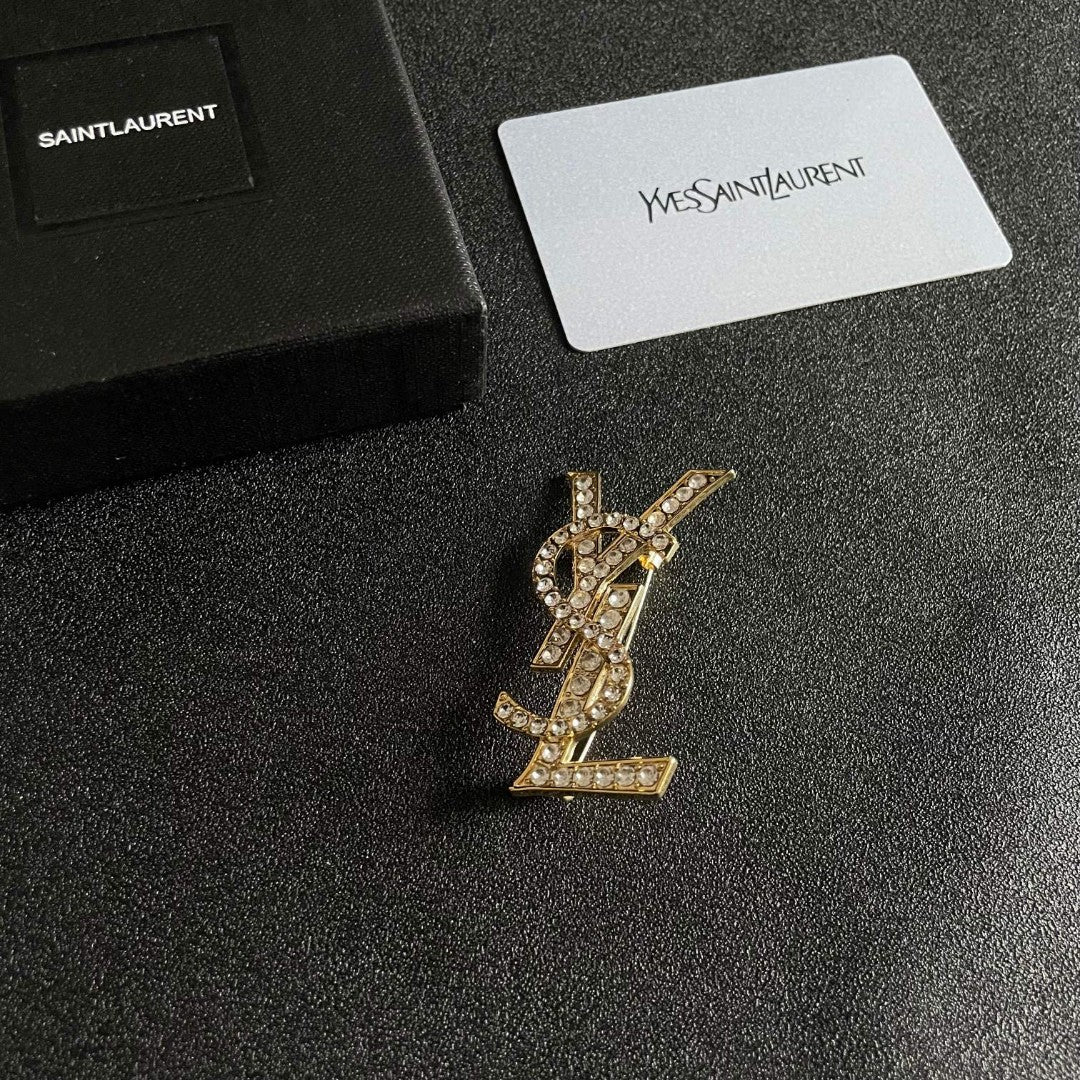 YSL 26S CRYSTAL MONOGRAM BROOCH IN GOLD TONE METAL 631043