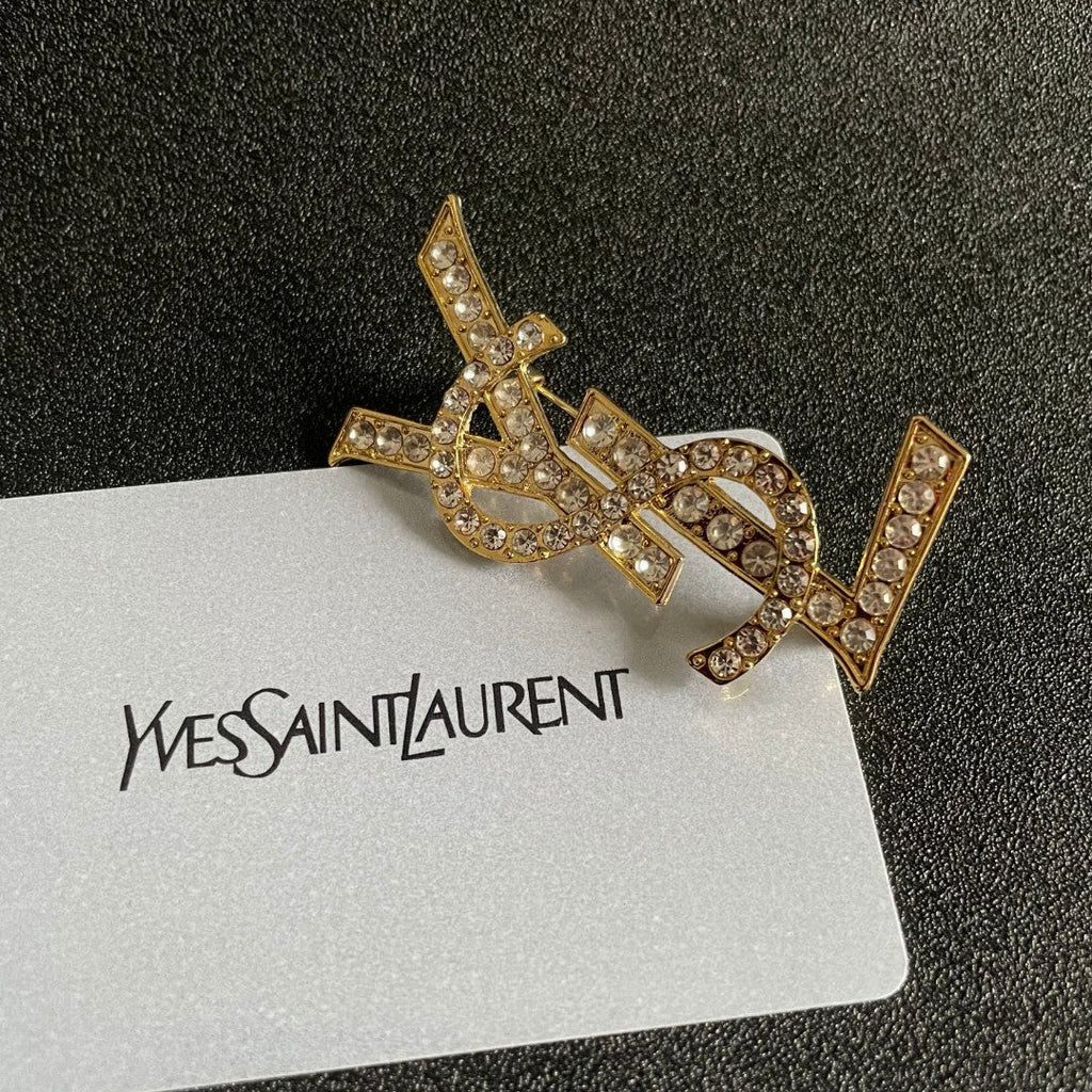 YSL 26S CRYSTAL MONOGRAM BROOCH IN GOLD TONE METAL 631043