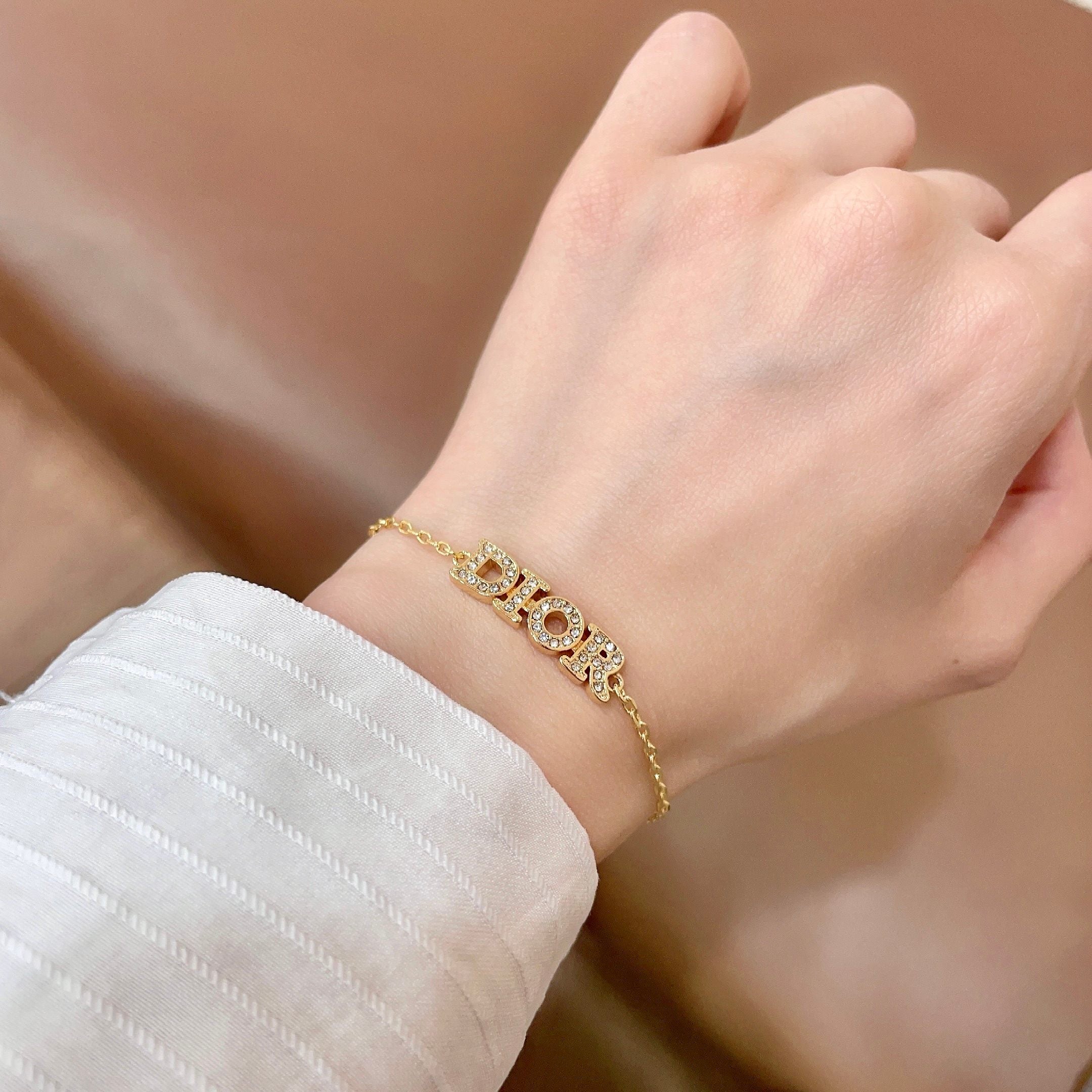 CD 26S PAVE LOGO LETTER BRACELET IN GOLD TONE METAL 631808