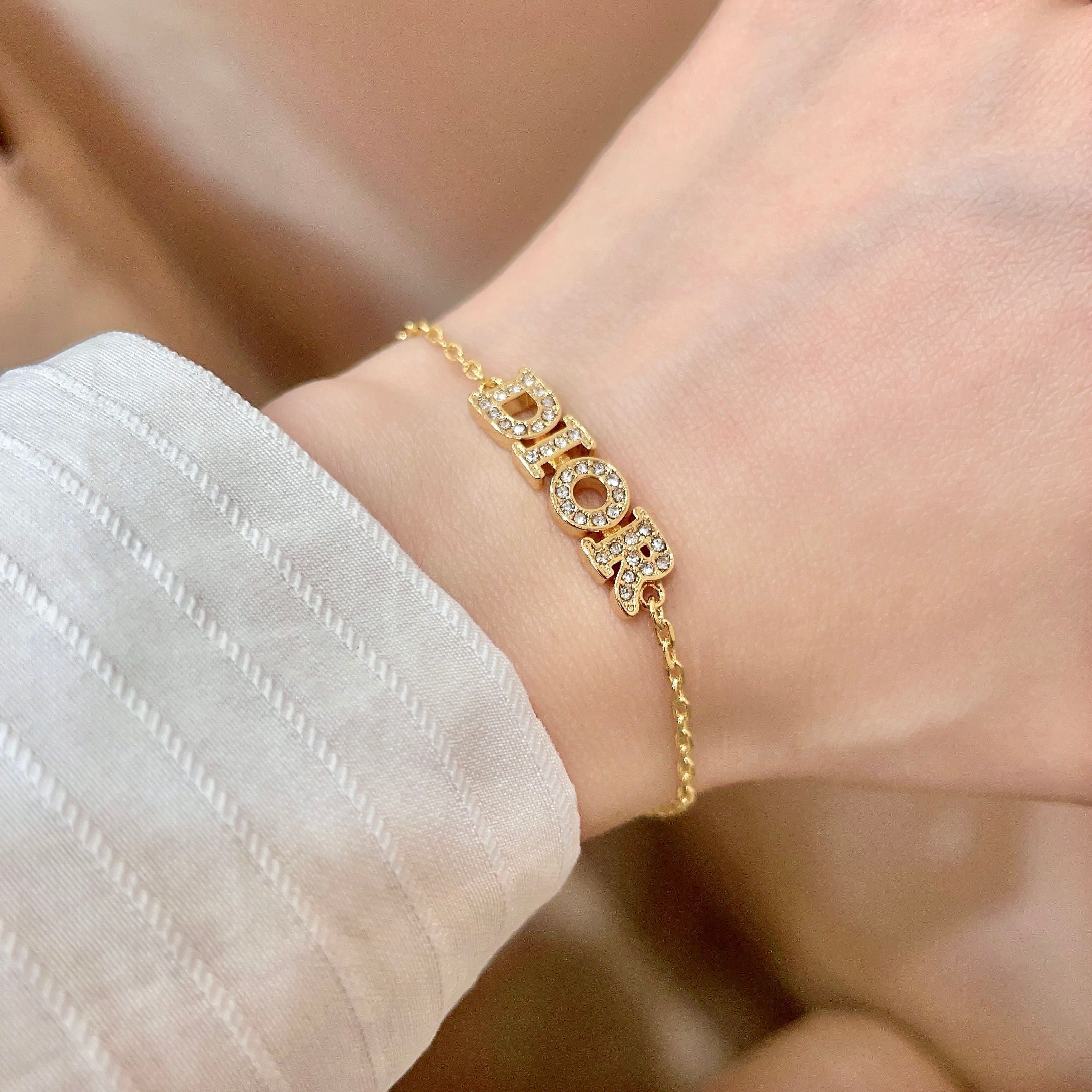 CD 26S PAVE LOGO LETTER BRACELET IN GOLD TONE METAL 631808