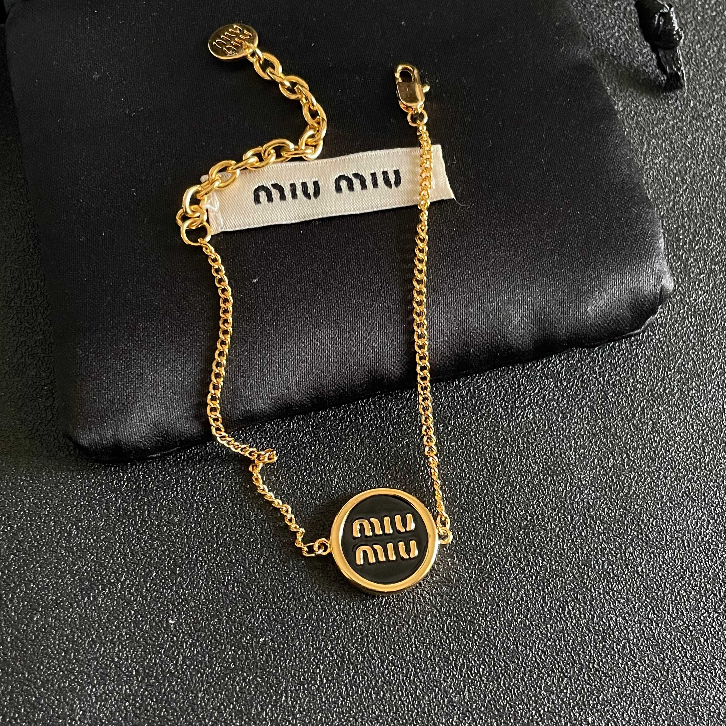 MIUMIU 26S LOGO ROUND BRACELET IN BLACK ENAMEL AND GOLD TONE METAL 631809