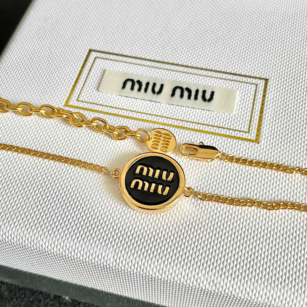 MIUMIU 26S LOGO ROUND BRACELET IN BLACK ENAMEL AND GOLD TONE METAL 631809