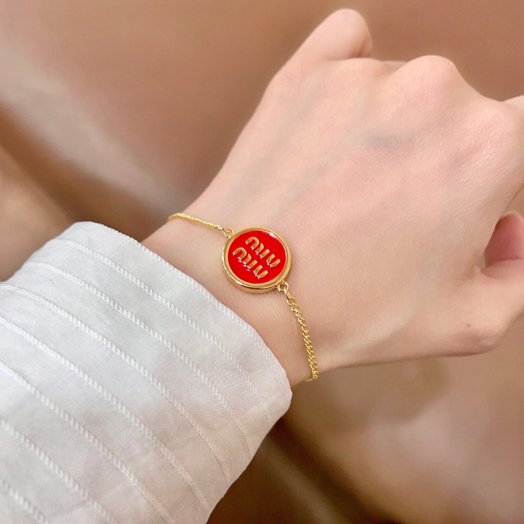 MIUMIU 26S LOGO ROUND BRACELET IN RED ENAMEL AND GOLD TONE METAL 631810