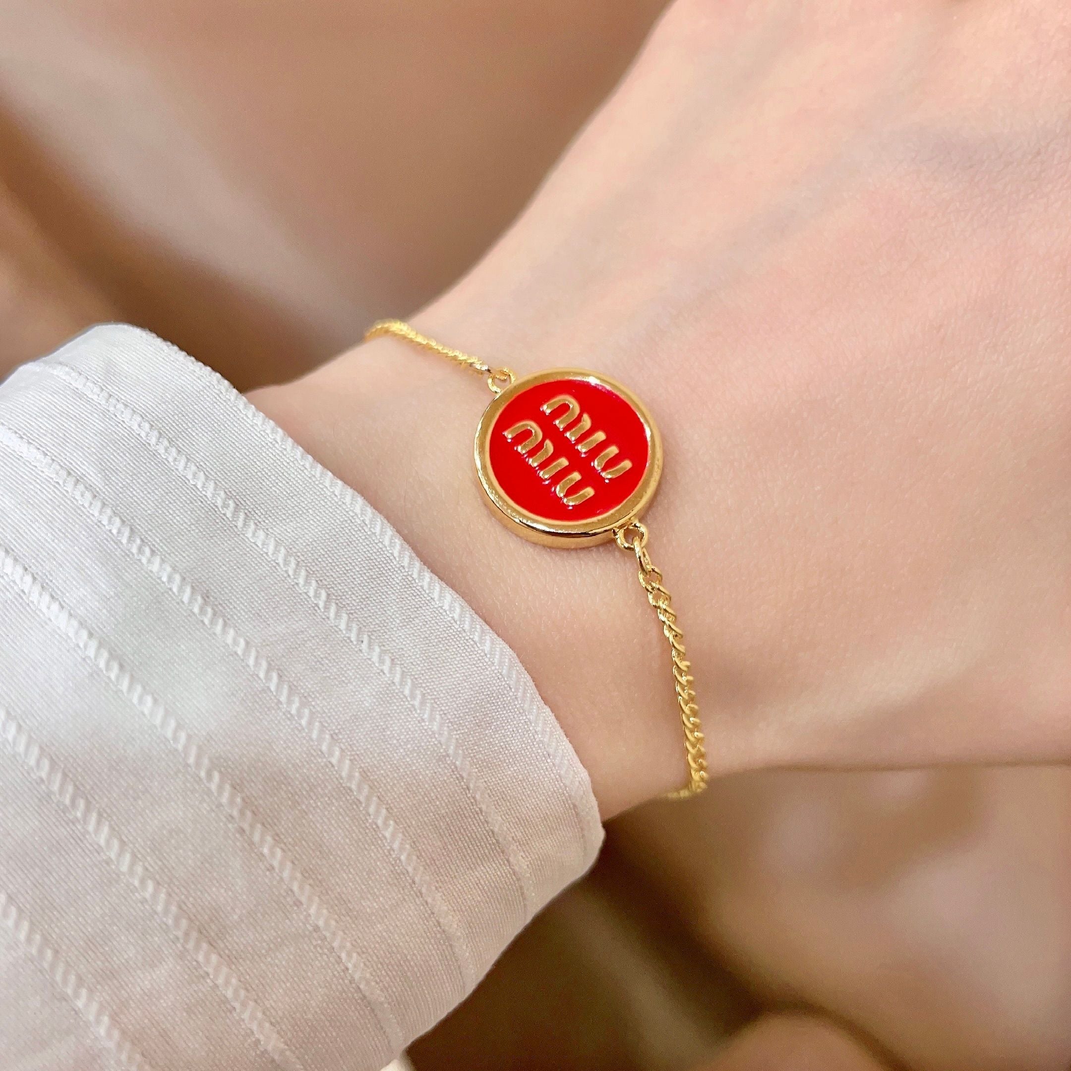 MIUMIU 26S LOGO ROUND BRACELET IN RED ENAMEL AND GOLD TONE METAL 631810