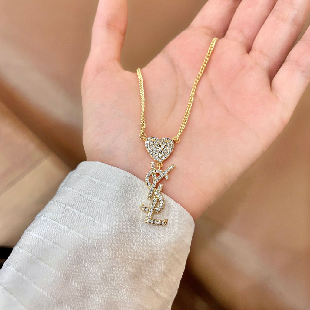 YSL 26S CRYSTAL HEART LOGO PENDANT NECKLACE IN GOLD TONE METAL 633939