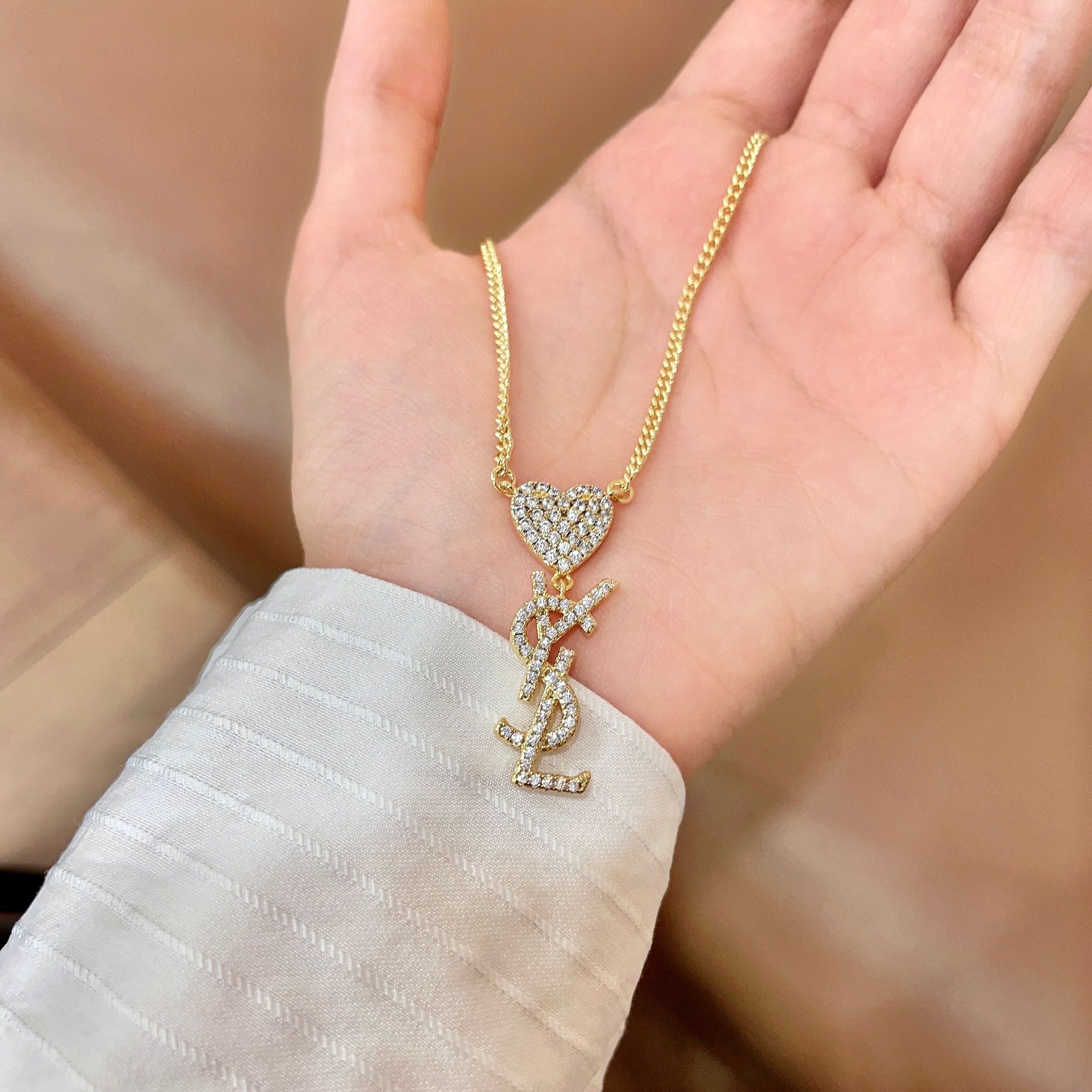 YSL 26S CRYSTAL HEART LOGO PENDANT NECKLACE IN GOLD TONE METAL 633939