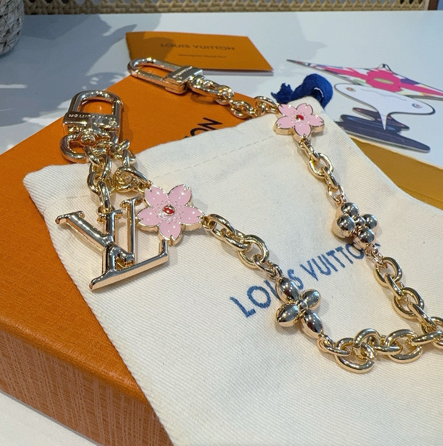 SAKURA BAG CHARM IN GOLD METAL HARDWARE